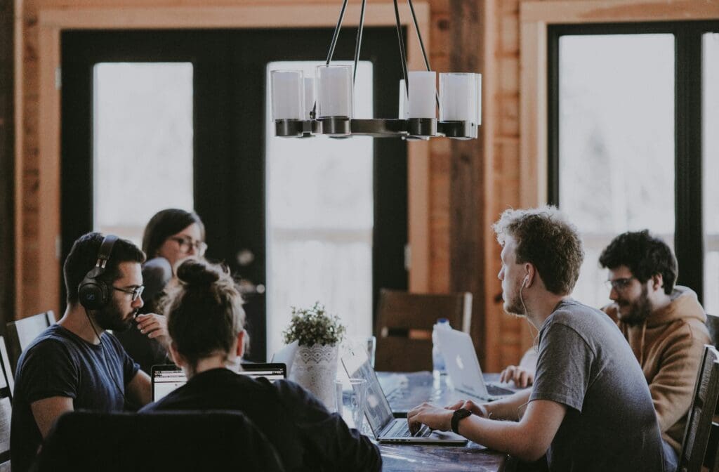 People working at a table on laptops.